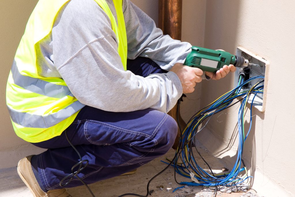 Electrician installing wires into a commercial building 